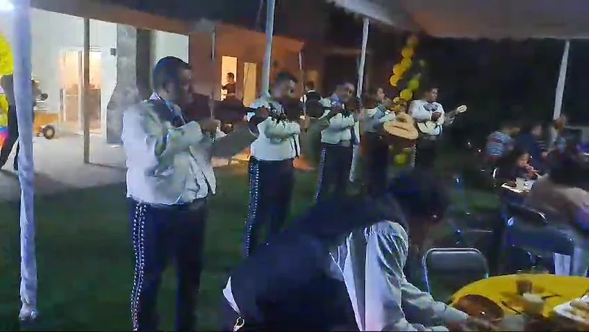Mariachi Insignia tocando en una reunión al anochecer