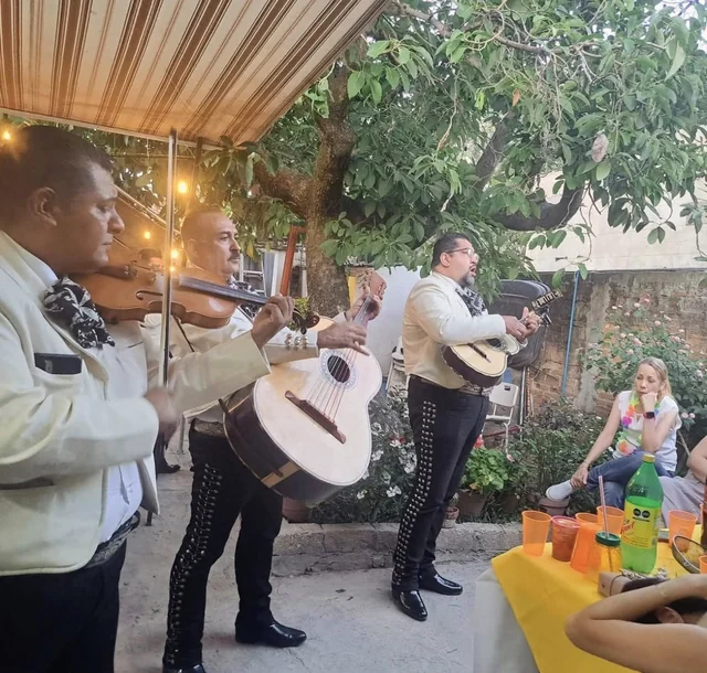 Tres músicos de Mariachi Insignia interpretando canciones en una reunión